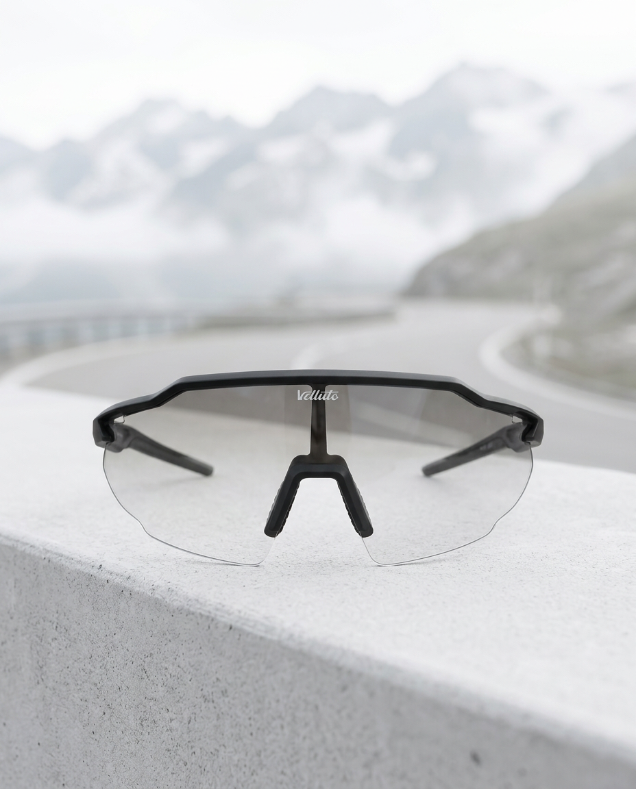 Velluto Chromo with black frame and clear lens on a light stone surface
